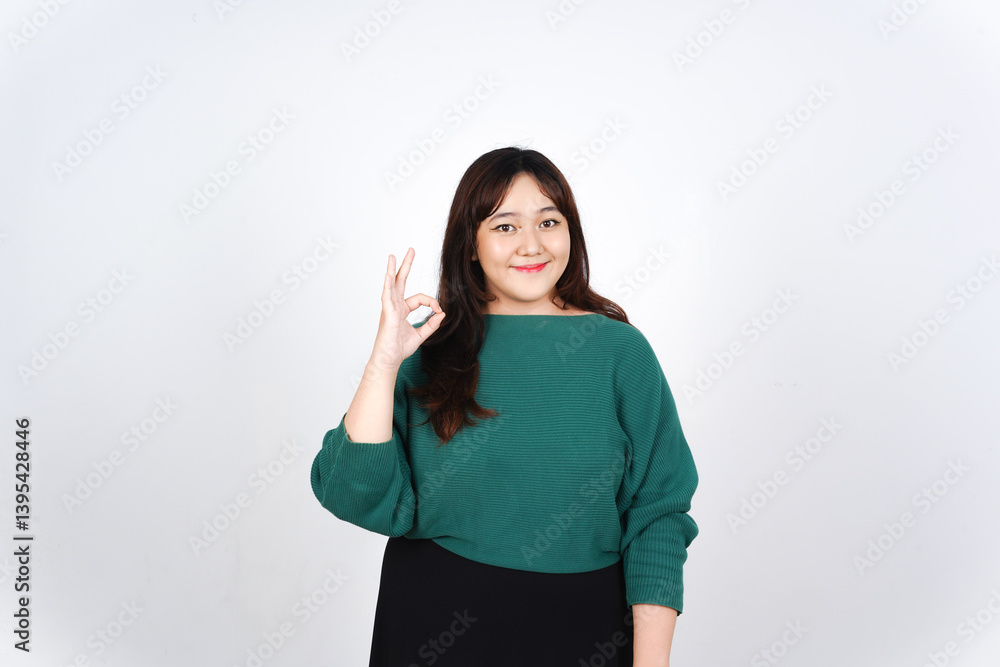 Showing okay sign or Approve Sign Of Beautiful Asian Woman Wearing Green Isolated On White Background Showing okay sign or Approve Sign Of Beautiful Asian Woman Wearing Green Isolated On White Background