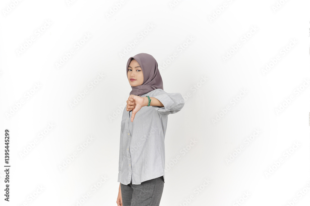Showing thumbs down, disagree sign Of Beautiful Asian Woman Wearing Hijab Isolated On White Background Showing thumbs down, disagree sign Of Beautiful Asian Woman Wearing Hijab Isolated On White Background