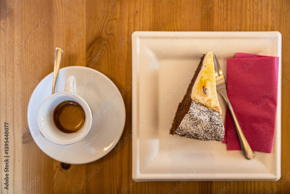 caffè espresso in tazza con dolce alla crema e pastafrolla al cacao, tipo crostata, di giorno, su un tavolo di legno, al bar
