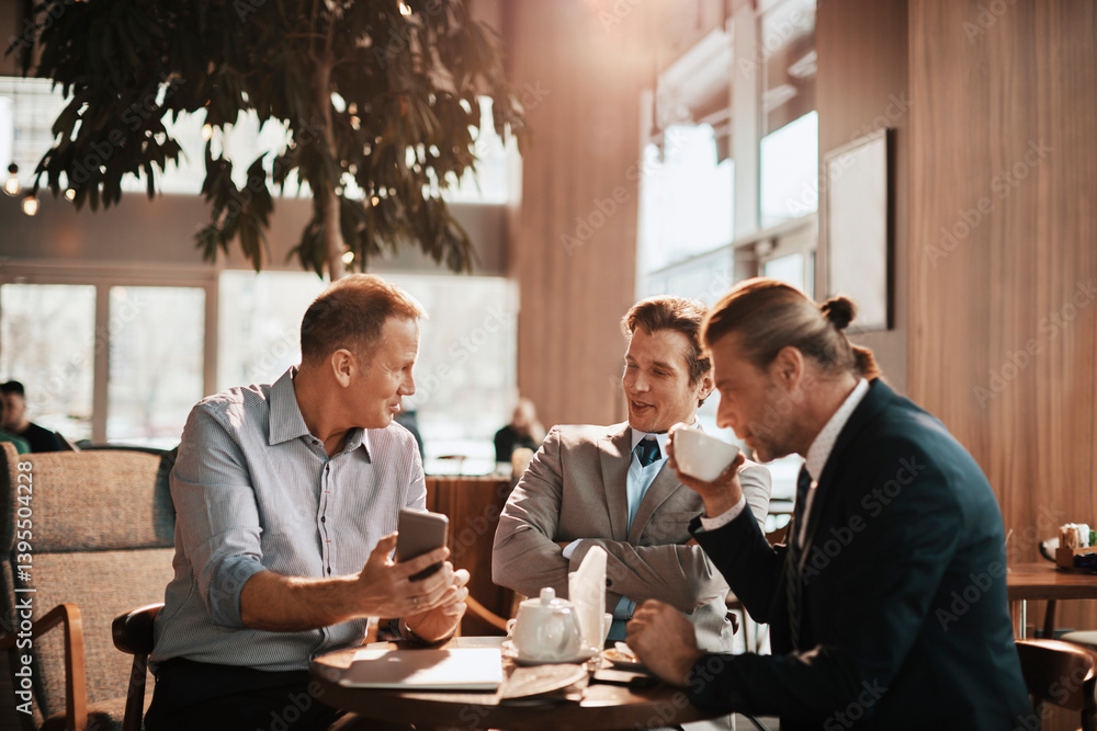 Businessmen having serious conversation over coffee in modern cafe