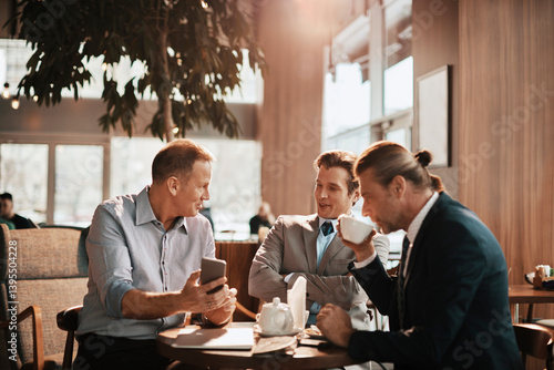 Obraz na płótnie Businessmen having serious conversation over coffee in modern cafe w salonie