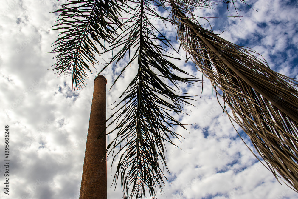 Chimney built with bricks, dry palm leaves and the sky with many clouds in the background, in Brazil