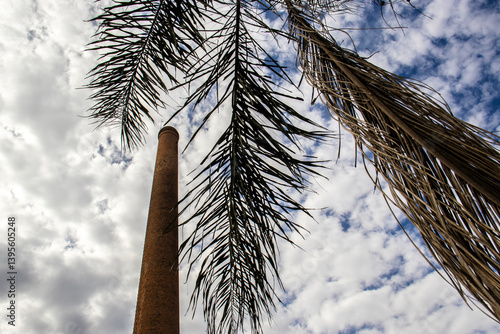Obraz na płótnie Chimney built with bricks, dry palm leaves and the sky with many clouds in the background, in Brazil w salonie