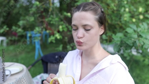 a young woman having breakfast in the garden in summer
