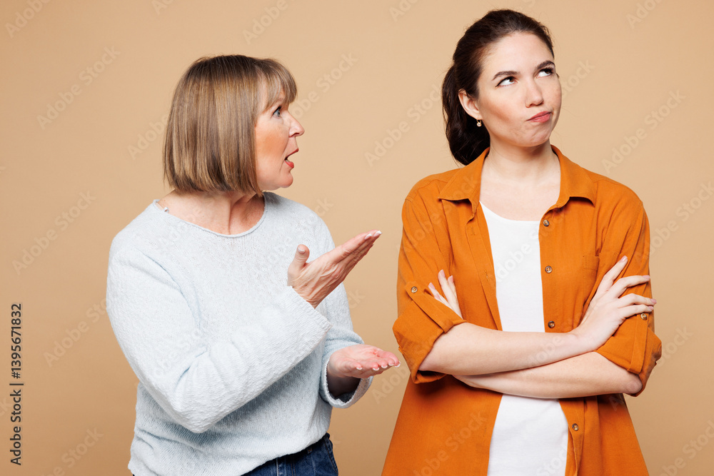 Elder sad mad angry dissatisfied parent mom 50s years old with young adult daughter two women together wear casual clothes scream scold isolated on plain pastel beige background. Family day concept. Elder sad mad angry dissatisfied parent mom 50s years old with young adult daughter two women together wear casual clothes scream scold isolated on plain pastel beige background. Family day concept.