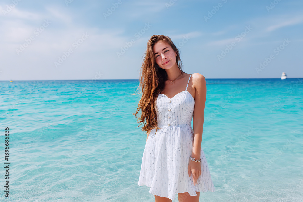 Woman in light summer dress enjoying a day at the beach in clear turquoise waters Woman in light summer dress enjoying a day at the beach in clear turquoise waters