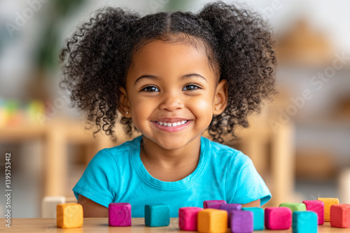 Preschool African child girl in blue t-shirt engages in fun learning activity with plastic blocks on a classroom table.