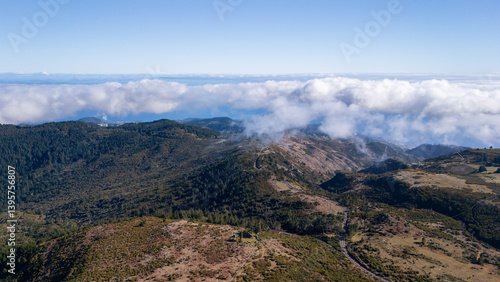 Breathtaking view of rolling mountains and clouds captured in a serene landscape during a clear day