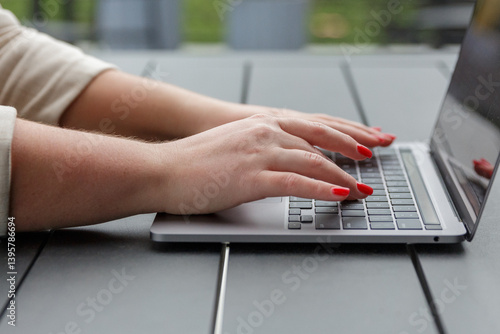 Closeup of businesswoman using laptop working remotely in a garden park background focusing on business efficiency in a natural outdoor workspace