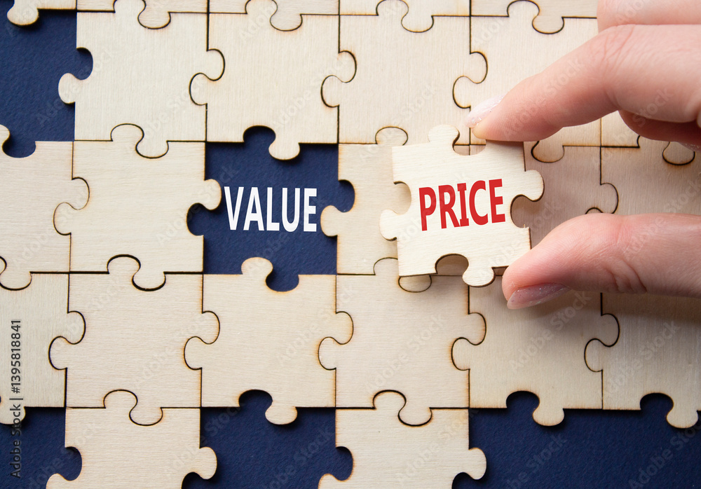 Price and Value symbol. Concept word Price and Value on wooden puzzle. Businessman hand. Beautiful deep blue background. Business and Price and Value concept. Copy space Price and Value symbol. Concept word Price and Value on wooden puzzle. Businessman hand. Beautiful deep blue background. Business and Price and Value concept. Copy space