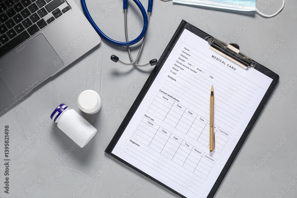 Medical card form, pen, pills and stethoscope on grey textured table, flat lay Medical card form, pen, pills and stethoscope on grey textured table, flat lay