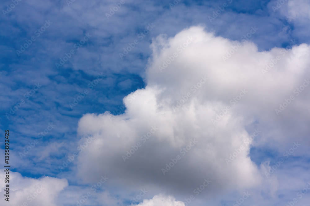 Obraz premium White cumulus clouds in a bright blue sky 