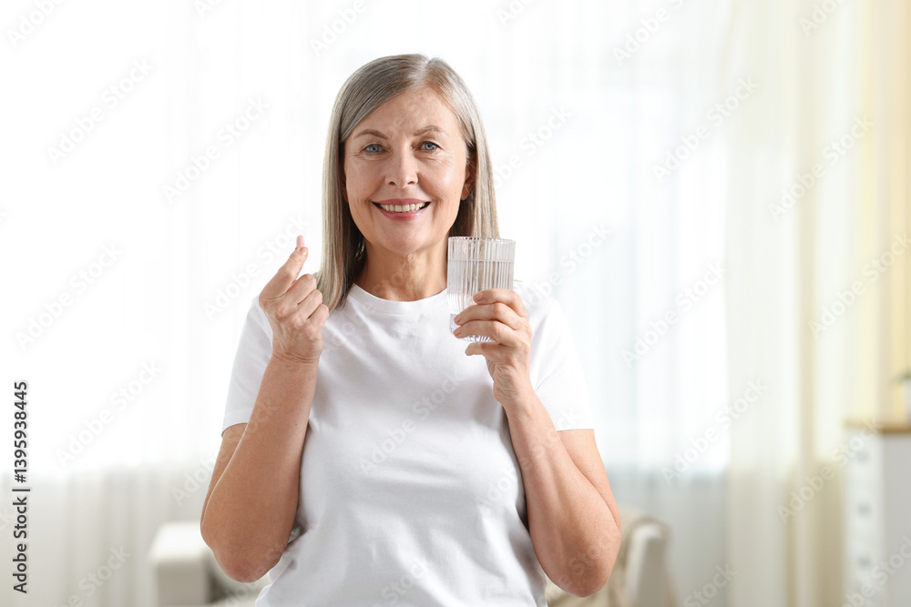 Smiling woman with collagen pill and glass of water at home Smiling woman with collagen pill and glass of water at home