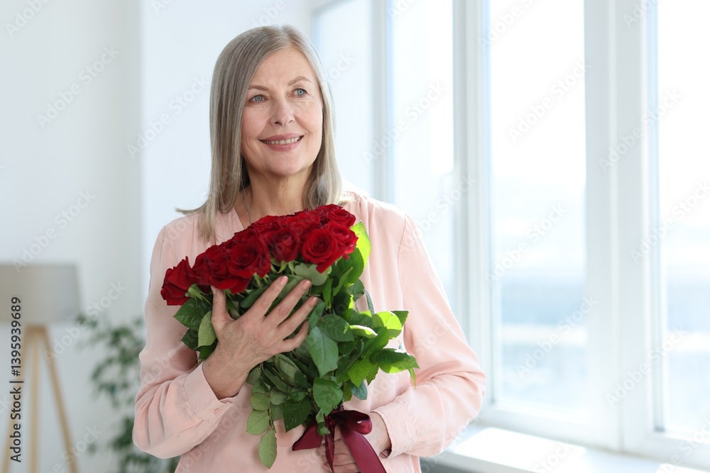 Smiling woman with bouquet of roses at home. Space for text