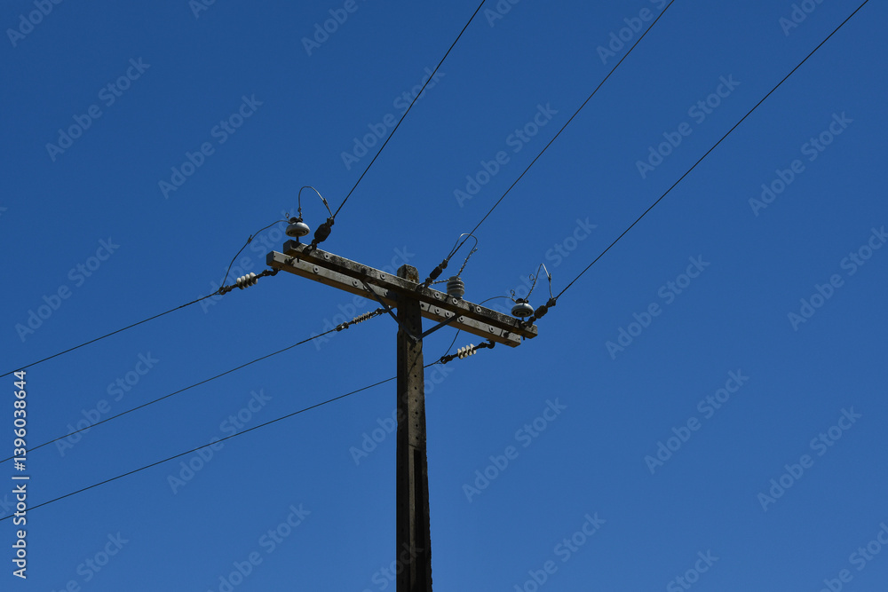 An electric pole of the power distribution network on a blue sky background An electric pole of the power distribution network on a blue sky background