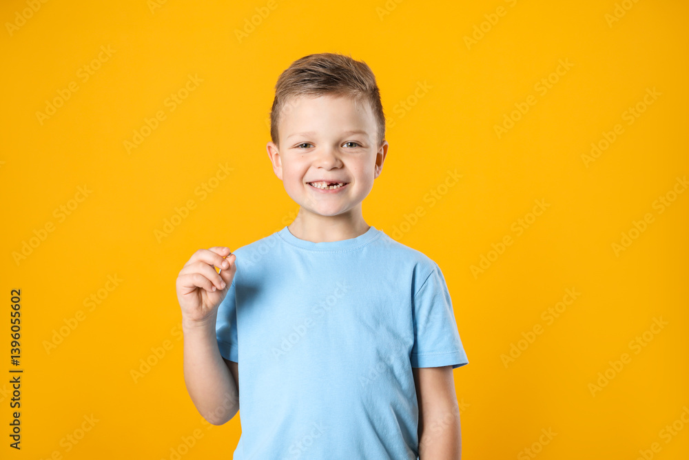 Cute little boy with missing tooth on orange background. Waiting for tooth fairy Cute little boy with missing tooth on orange background. Waiting for tooth fairy