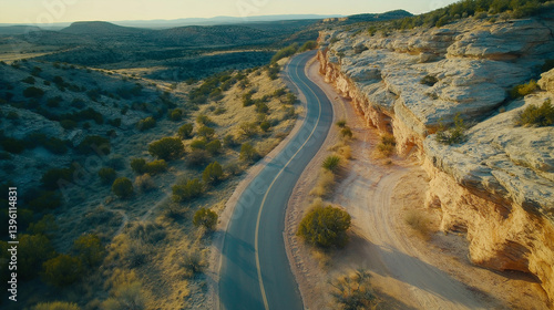 Aerial view of winding paved road through arid desert landscape.