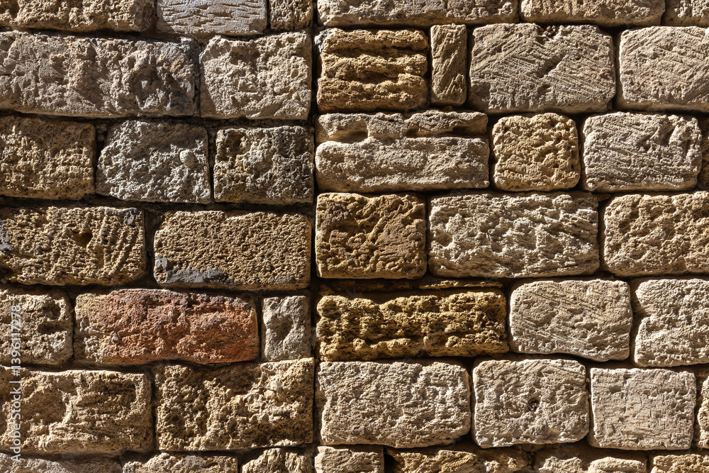 Natural shell rock stone brick wall showcasing its rustic rough texture