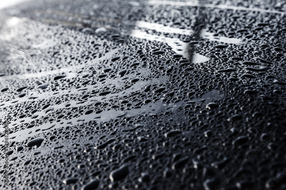 A detailed shot of water droplets forming on a smooth metallic surface