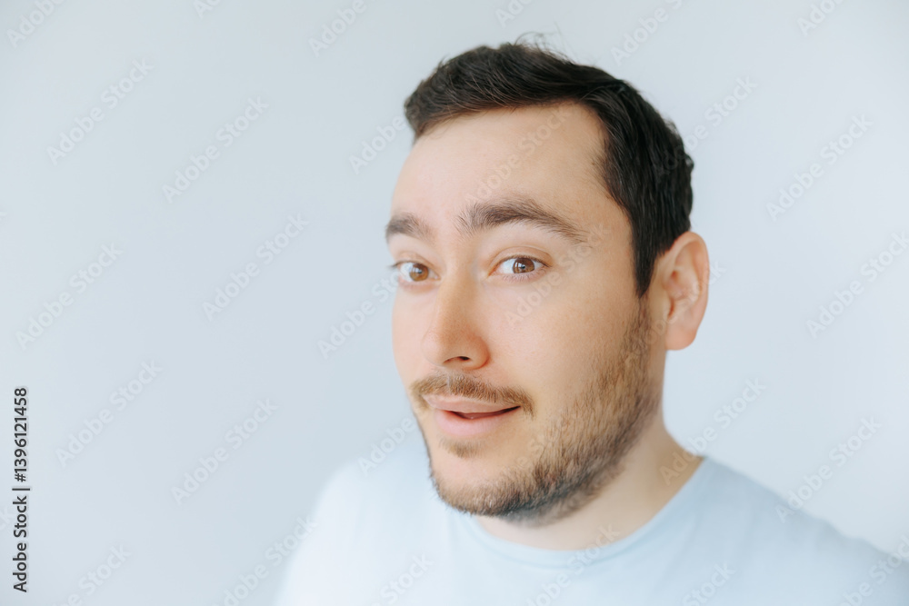 Fototapeta premium Man with light beard expressing surprise in a bright indoor space
