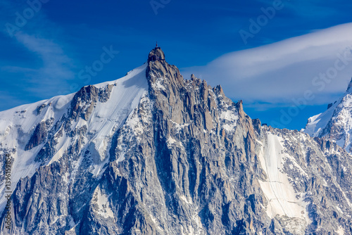 Aiguille du Midi peak in the Alps. Chamonix valley landscape of a prominent rocky towering mountain peak in French Alps. Chamonix-Montblanc area beautiful landscape of Aiguille du Midi summit, France