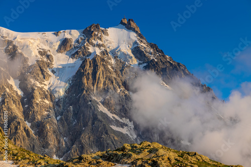 Aiguille du Midi peak in the Alps. Chamonix valley landscape of a prominent rocky towering mountain peak in French Alps. Chamonix-Montblanc area beautiful landscape of Aiguille du Midi summit, France