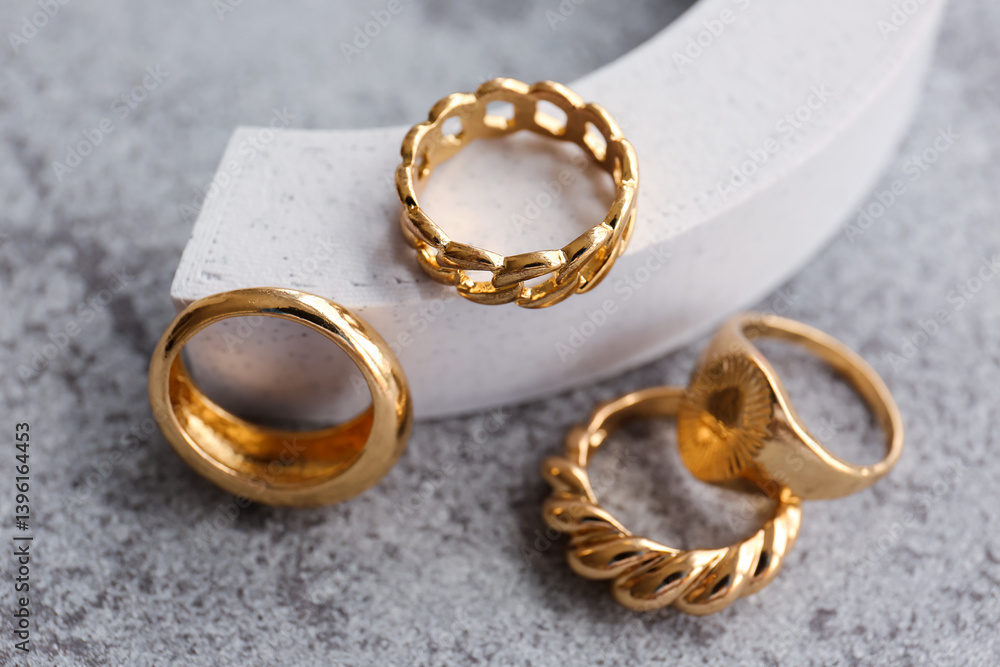 Decorative podium with different golden rings on grunge grey background Decorative podium with different golden rings on grunge grey background