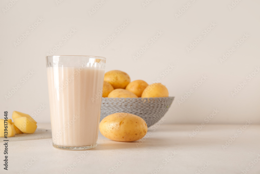 Glass of tasty potato milk on light background Glass of tasty potato milk on light background