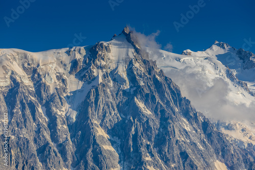 Aiguille du Midi peak in the Alps. Chamonix valley landscape of a prominent rocky towering mountain peak in French Alps. Chamonix-Montblanc area beautiful landscape of Aiguille du Midi summit, France