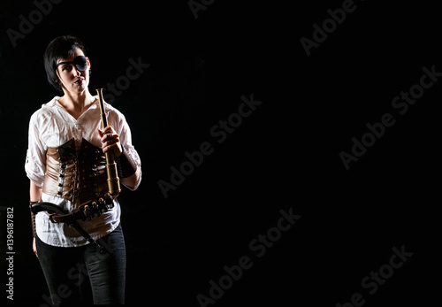 Obraz na płótnie Woman pirate girl holding vintage spyglass with short hair, pistol and eye patch in white shirt on a black background. Dramatic light. Free space w salonie