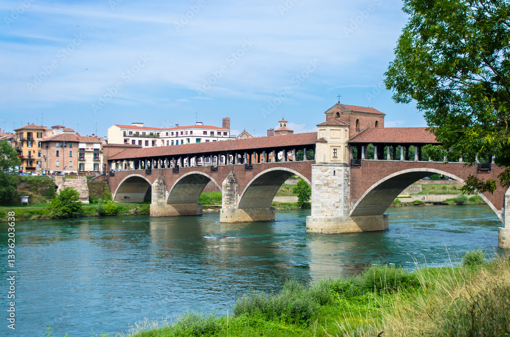 Naklejka premium Panorama del Ponte Coperto di Pavia, simbolo della città, che attraversa il fiume Ticino