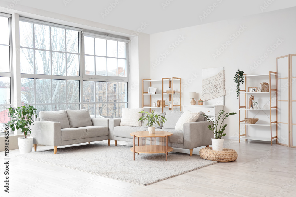 © Pixel-Shot - Interior of light living room with grey sofas, shelf units and window