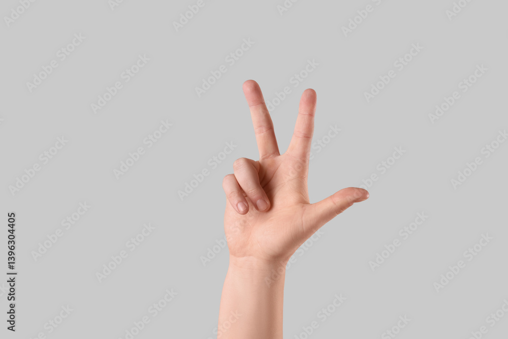 Male hand showing three fingers on light background Male hand showing three fingers on light background