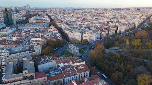 Stunning aerial drone shots of Madrid at sunset, featuring the iconic Puerta de Alcal and El Retiro park amidst a vibrant cityscape and history of Europe. Spain