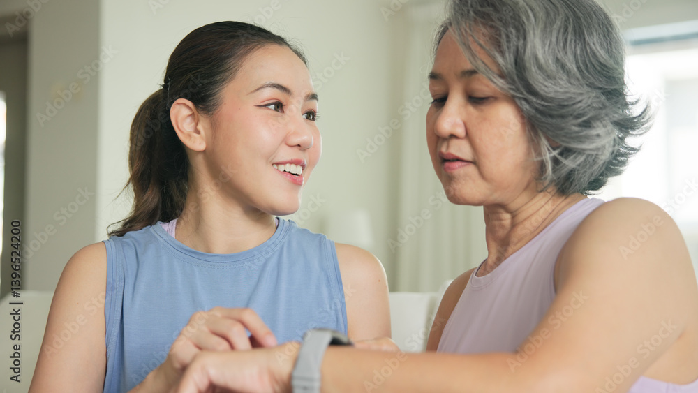 Young adult child give gift AI smart watch IOT app to mature middle age old mum. Love health care older mom asia elder people sit at home sofa happy family wear wrist trace help protect aging life. Young adult child give gift AI smart watch IOT app to mature middle age old mum. Love health care older mom asia elder people sit at home sofa happy family wear wrist trace help protect aging life.