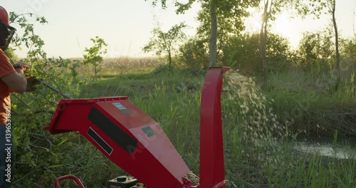 Garden worker using wood chipper shredder for making mulch