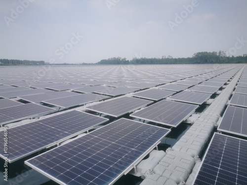 A large number of solar panels are installed on gray plastic pontoons over a body of water.