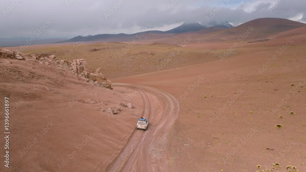 Drone Following SUV Driving on Dirt Road Near Rocky Formations en Route to Pastos Grandes Lake in Bolivia Drone Following SUV Driving on Dirt Road Near Rocky Formations en Route to Pastos Grandes Lake in Bolivia