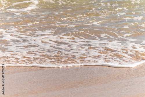 calm ocean waves meeting sandy shore, detailed coastal texture sand closeup view