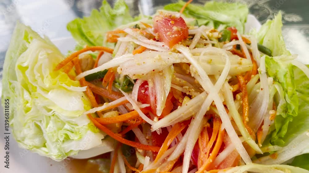Closeup of delicious Thai Papaya Salad, slow handheld tracking shot.