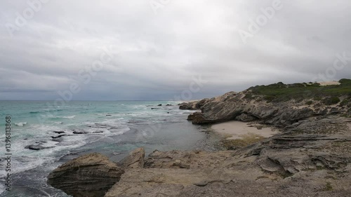 Heavy grey overcast cloud above sand and limestone beach, copy space