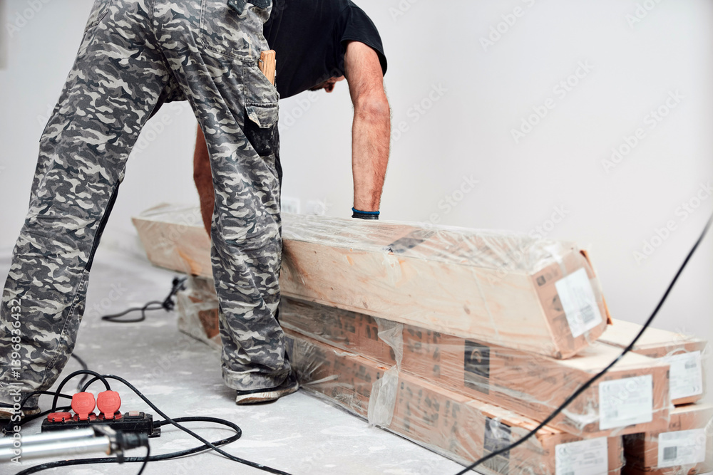 Professional handyman installing laminate flooring in a new apartment.