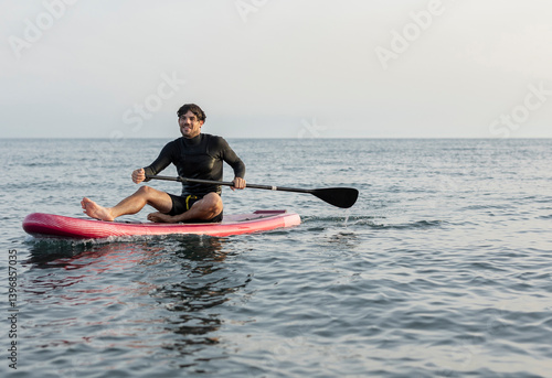 Wallpaper Mural Man enjoying paddleboarding on calm ocean water Torontodigital.ca