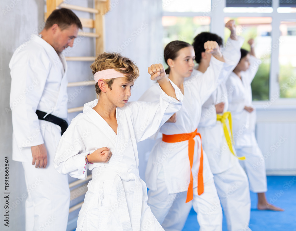 Group of karate kids practicing karate technique in gym Group of karate kids practicing karate technique in gym