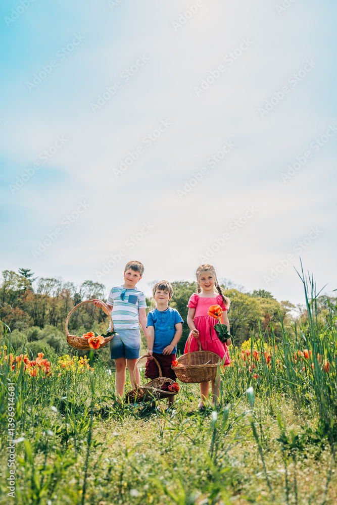 Three kids standing in tulip field holding flower baskets Three kids standing in tulip field holding flower baskets