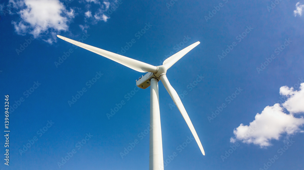 Wind turbine against the blue sky generating renewable energy power Wind turbine against the blue sky generating renewable energy power