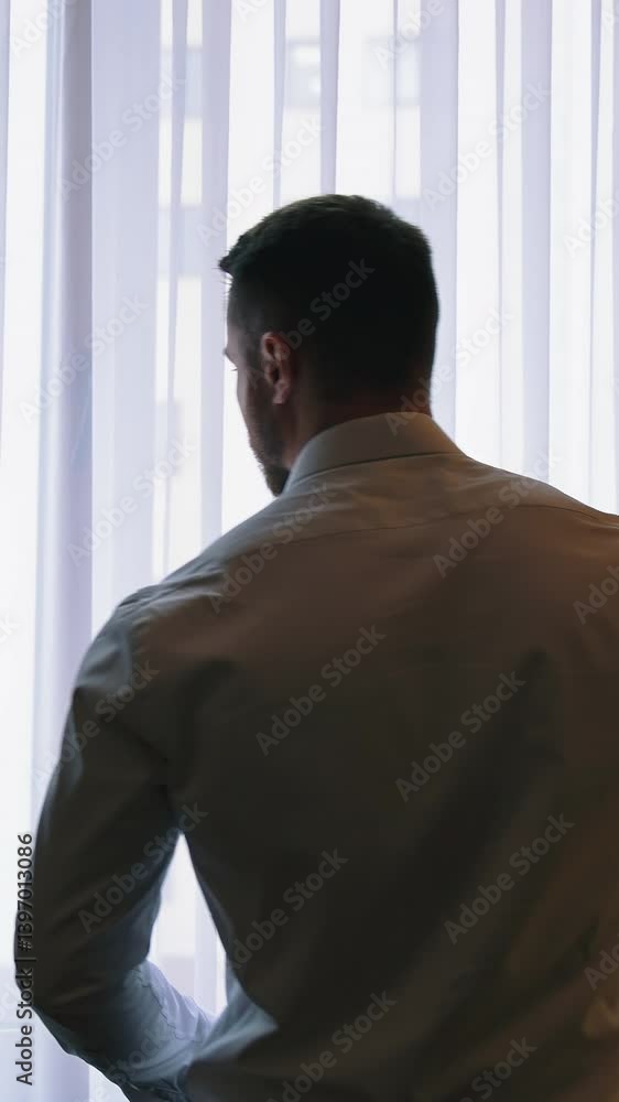 Businessman in luxury room of hotel. Successful businessman looking into window at his hotel. Vertical video Businessman in luxury room of hotel. Successful businessman looking into window at his hotel. Vertical video