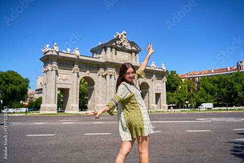 Tourist dancing in front of puerta de alcalá in madrid, spain