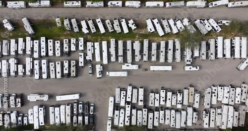 Dealers outdoor parking lot with many brand new travel trailers and campervans in stock for sale. Concept of development of American RV automotive industry.