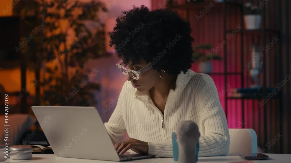 Stylish female graphic designer in eyeglasses working on laptop, writing notes Stylish female graphic designer in eyeglasses working on laptop, writing notes